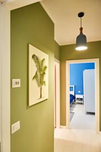 a hallway with a painting of a palm tree on a green wall at Riviera Marco Polo in Mestre