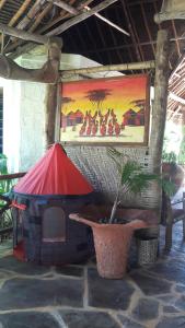 
a table with an umbrella in front of a building at African Dream Cottages - Diani Beach in Diani Beach
