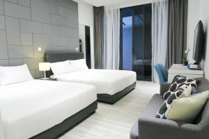 a hotel room with two beds and a couch at RR Cozy Studio & Suite in Singapore