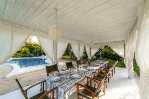 a long dining room with a table and chairs at Nyumba Ya Mbuyu in Malindi
