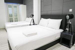 two white beds in a room with a camera on it at ReCharge Cozy Room Suite in Singapore