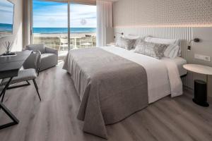 - une chambre avec un grand lit et une vue sur l'océan dans l'établissement Bel Air, à Castelldefels