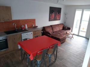 - un salon avec une table rouge et un canapé dans l'établissement les vignes Ardéchoises - Peuplier, à Sarras
