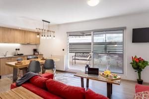 salon z czerwoną kanapą i kuchnią w obiekcie Supreme Comfort Apartments by Athens Stay w Atenach