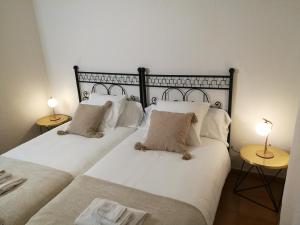 two beds in a room with two lamps on tables at El Paller de Can Puig a la Pera 4/6 pax in La Pera