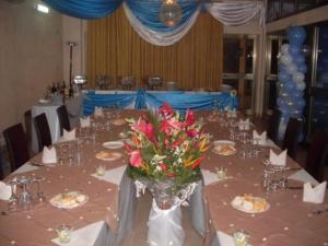 ein langer Tisch mit einer Vase mit Blumen darauf in der Unterkunft Hôtel Saint Thomas in Lomé