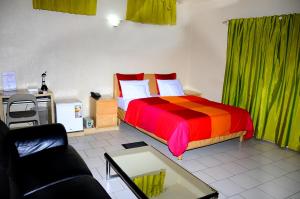 a bedroom with a bed with a colorful comforter at Hôtel Saint Thomas in Lomé