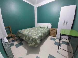 een slaapkamer met een bed en een groene muur bij Residencial Hinojosa in Oruro