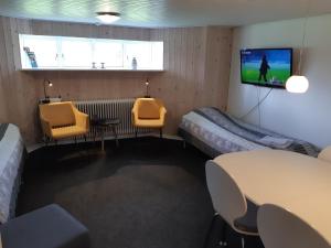 a room with two beds and a tv on the wall at Sdr. Omme Bed & Breakfast in Sønder Omme