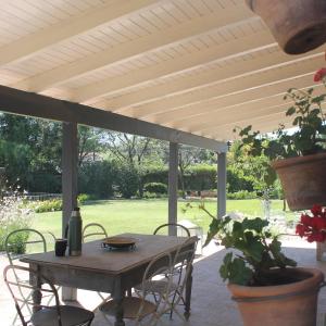 a wooden table and chairs on a patio at Complejo Arboreto in San Pedro