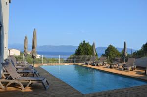 a swimming pool with lounge chairs and umbrellas at Résidence Giovanello in Porto Pollo