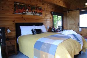 1 dormitorio con 1 cama en una cabaña de madera en Sunset Chalet, en Lake Tekapo