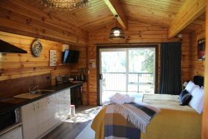 a bedroom in a log cabin with a bed and a sink at Sunset Chalet in Lake Tekapo