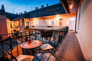 a balcony with a table and chairs and a building at Luxury Smart Apartments in Szeged