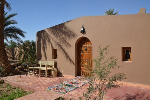 a house with a door and a table and chairs at Mhamid Auberge Saharaespace in Mhamid