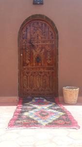 a wooden door with a rug in front of it at Mhamid Auberge Saharaespace in Mhamid