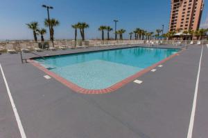 an empty swimming pool with chairs and a building at Regency Isle 411 in Orange Beach