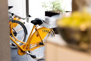 Una bicicleta amarilla estacionada junto a una mesa con un portátil. en Lendhotel, en Graz