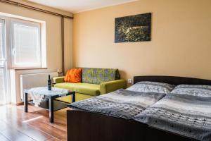 um quarto com uma cama, um sofá e uma mesa em Ubytování ve Vinařství Medek | Medek House & Winery em Uherské Hradiště