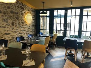 a dining room with tables and chairs and windows at Les Chiens du Guet in Saint Malo
