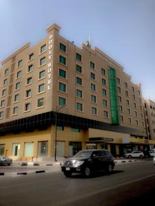 فندق دولف الخبر  في الخبر: سيارة سوداء القيادة أمام مبنى كبير