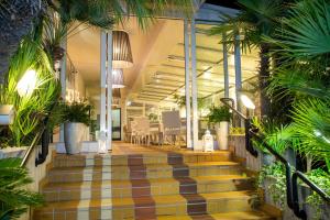 un vestíbulo con escaleras y plantas en un edificio en Hotel Santiago, en Lido di Jesolo