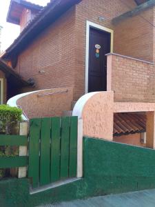 a house with a green gate and a black door at APduda 1 e 2 no chales do parque in Monte Verde