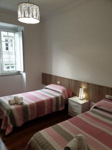 a bedroom with two beds and a window at Pensión Hedrass in Santiago de Compostela