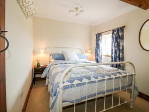 a bedroom with a bed and a window at Bellamour End Cottage in Rugeley