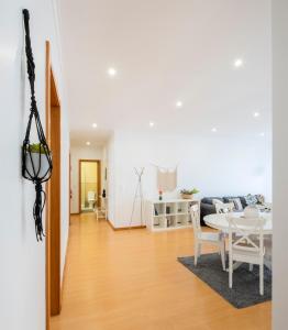 uma sala de estar branca com uma mesa e um sofá em Paim Apartments em Ponta Delgada