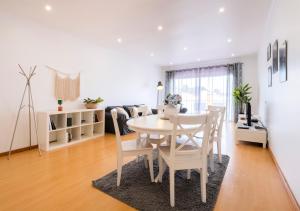uma sala de jantar branca com uma mesa e cadeiras em Paim Apartments em Ponta Delgada