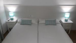 Łóżko lub łóżka w pokoju w obiekcie Hostal VILLA CARBULA