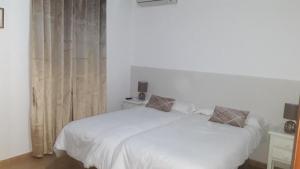Łóżko lub łóżka w pokoju w obiekcie Hostal VILLA CARBULA