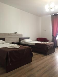 Duas camas num quarto com pisos em madeira em Hotel Karpaty em Ivano-Frankivsʼk