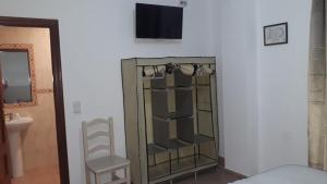 sypialnia ze szklaną szafką i krzesłem w obiekcie Hostal VILLA CARBULA w mieście Almodóvar del Río