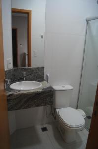 a bathroom with a toilet and a sink at Ventura Hotel in Barreiras
