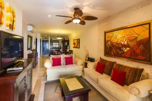 a living room with two couches and a ceiling fan at El Faro 301 Coral in Playa del Carmen