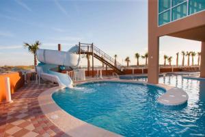 a swimming pool with a slide in a resort at Phoenix Gulf Shores 2102 in Gulf Shores +42 photos