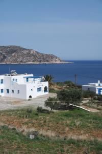 a white house on a hill next to the ocean at Sea View Studios in Amoopi