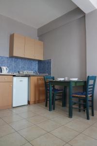 a kitchen with a table and chairs and a table and a refrigerator at Sea View Studios in Amoopi