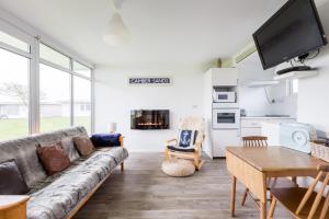 a living room with a couch and a table at The Beach Huts - Camber Sands in Camber