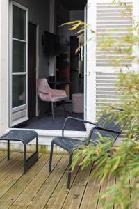 a patio with two chairs and a chair on a porch at Empreinte Hotel & Spa in Orléans