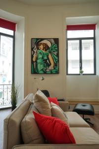 ein Wohnzimmer mit einem Sofa und einem Gemälde an der Wand in der Unterkunft Marquês Modern Art apartment in Lissabon