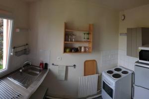uma pequena cozinha com um lavatório e um fogão em Studio de la zone de Courtabœuf Les Ulis 91940 em Les Ulis