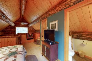 ein Schlafzimmer mit einem Bett und einem TV in einer Hütte in der Unterkunft Bear Hollow Cabin in Tacoma
