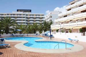 a swimming pool with a hotel in the background at Club Olympus in Garden City in Playa de las Americas