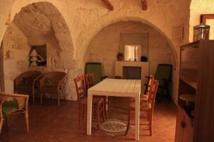 - une cuisine et une salle à manger avec une table et des chaises dans l'établissement Il Trullo di Leonardo - casa uso turistico, à Martina Franca