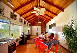 a kitchen with a table with red chairs and a ceiling fan at Magic Mountain Views Studio in Atenas