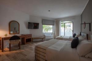 a bedroom with a bed and a desk and a mirror at Gaviana Resort in Mazatlán
