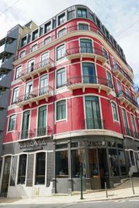 ein rotes Gebäude an der Ecke einer Straße in der Unterkunft Marquês Modern Art apartment in Lissabon